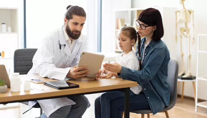 Médico explicando opciones de seguros esenciales de salud ASISA a una madre y su hija